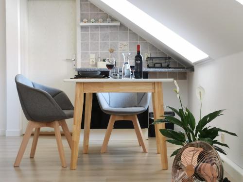 a table with two chairs and a bottle of wine at Fynbos Studio DG in der Altstadt, Frauenkirchenblick, Parkplatz in Meißen