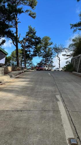 an empty street with trees on the side of the road at Serenity Vacation House in Baguio