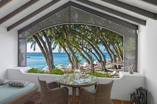 Cette chambre dispose d'une table et offre une vue sur la plage. dans l'établissement Colony Club by Elegant Hotels, à Saint James