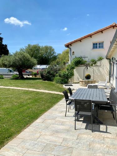 un patio avec une table et des chaises dans une cour dans l'établissement Chambre d'hôtes La Belgerie, à Saint-Michel-en-lʼHerm