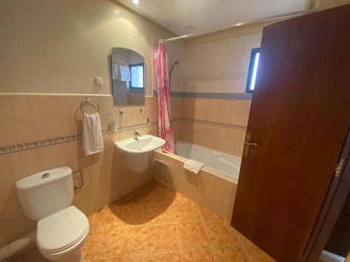 a bathroom with a toilet and a sink and a tub at Hotel Residence Rihab in Agadir