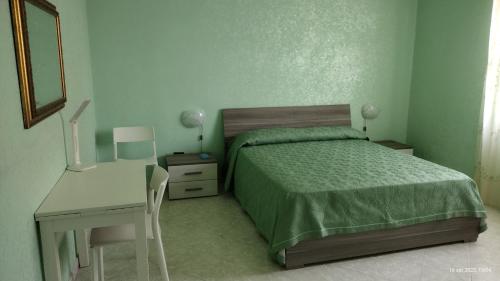 een slaapkamer met een bed, een tafel en een bureau bij Villa Grazia in Ladispoli