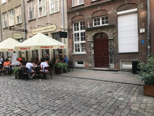 a group of people sitting at tables outside a building at Przytulny Apartament w samym centrum Gdańska in Gdańsk