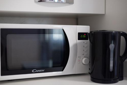 a microwave sitting on a counter next to a coffee mug at Roma Marine House in Lido di Ostia