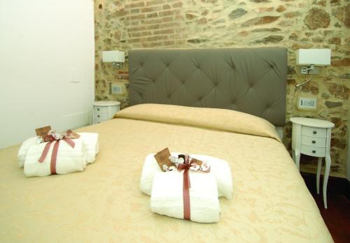 una camera da letto con un grande letto con asciugamani di B&B La Loggia e L’Orologio a Castiglione del Lago