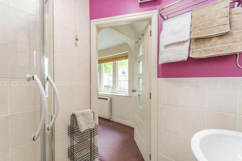 a bathroom with purple walls and a sink and a mirror at The Friendly Room in Austwick