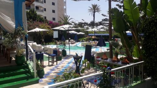 a resort with a pool and tables and chairs at Hotel Residence Rihab in Agadir