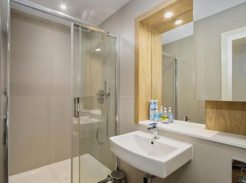 a white bathroom with a sink and a shower at 602 Luxury Apartment near Luton Town and Station in Luton
