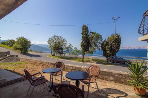 a patio with chairs and tables and a view of the water at Apartment Luka in Senj