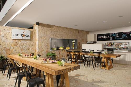 um restaurante com mesas e cadeiras de madeira e uma parede de pedra em Breathless Cabo San Lucas - Adults Only em Cabo San Lucas