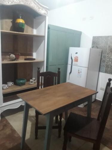 cocina con mesa de madera y nevera en LOFT "sencillito" a pasos de la RUTA 34 en Rafaela