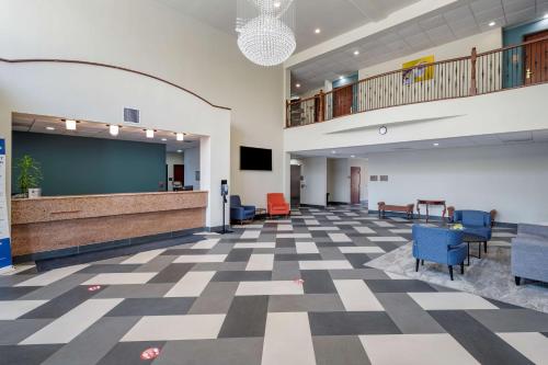 a large lobby with a blackboard and blue chairs at Best Western Plus McKinney Inn and Suites in McKinney