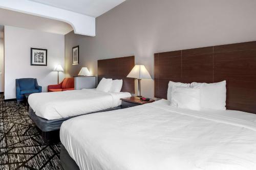 a hotel room with two beds and a chair at Best Western Plus McKinney Inn and Suites in McKinney