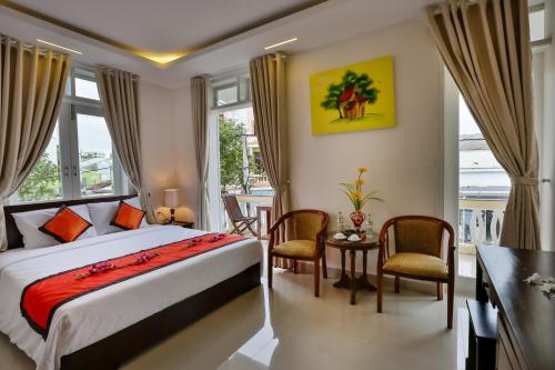 a bedroom with a bed and a table and chairs at Han Huyen Homestay in Hoi An