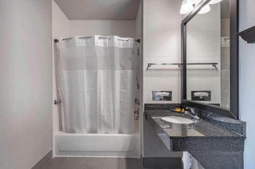 a white bathroom with a shower and a sink at Best Western Plus McKinney Inn and Suites in McKinney