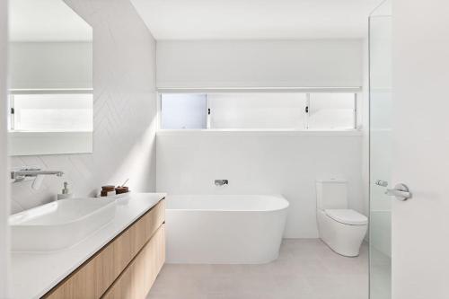 a white bathroom with a sink and a toilet at HideAway I at Shoal Bay in Shoal Bay