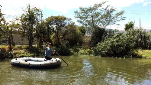 a man is rowing a raft on a river at Hostería Colibri Aeropuerto in Tababela