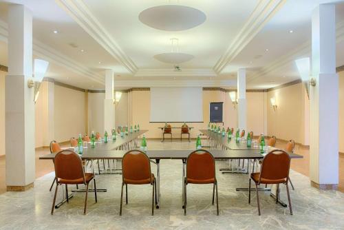 a meeting room with a long table and chairs at NH Ravenna in Ravenna