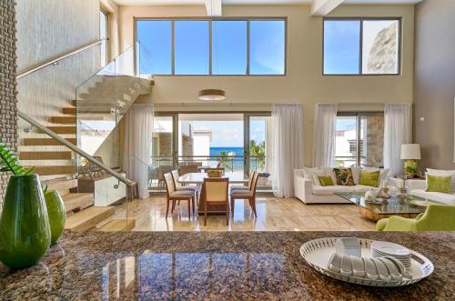 uma grande sala de estar com mesa e cadeiras em Costa Atlantica Punta Cana - Beach Vacation Condos em Punta Cana