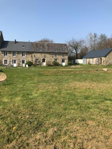 a large yard with a large stone house at Escale de Gerbold in Gratot