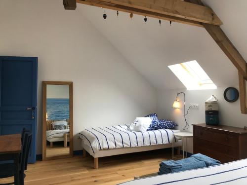 a bedroom with a bed and a mirror at Escale de Gerbold in Gratot
