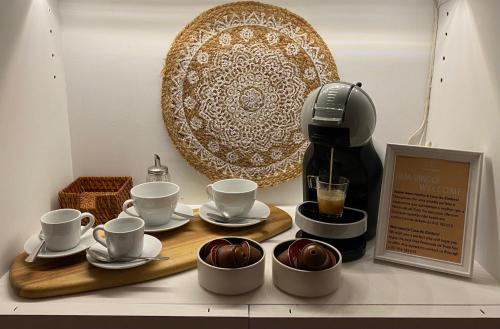 una mesa con tazas, una cafetera y un plato en Casa do Zimbro, en Tróia