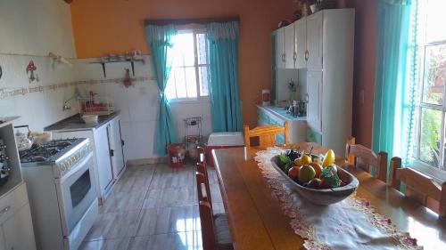 a kitchen with a table with a bowl of fruit on it at Jorge casa de las Orquídeas in El Soberbio