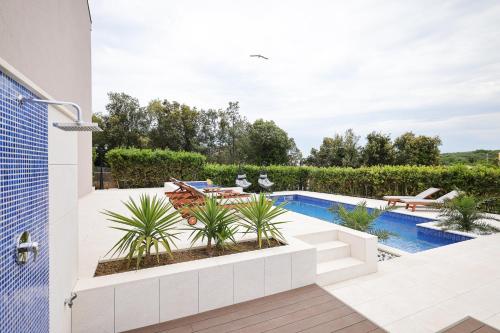 a backyard with a swimming pool and a patio at Villa Pino with Pool, Sauna & Jacuzzi in Petrcane