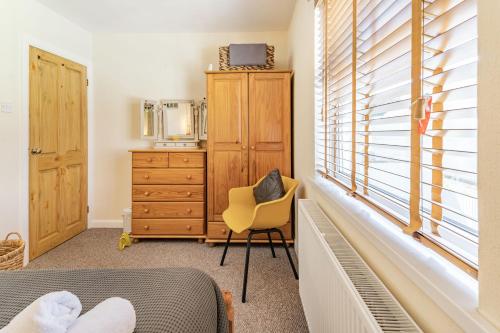 sypialnia z łóżkiem, krzesłem i oknem w obiekcie Dringarth w mieście Tenby
