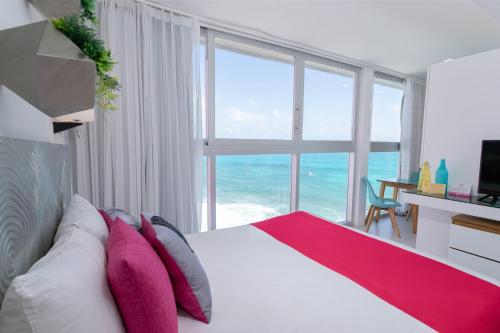 a bedroom with a bed with a view of the ocean at Mia Reef Isla Mujeres - All Inclusive Resort in Isla Mujeres