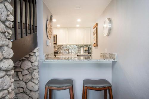 a kitchen with two stools in front of a counter at Beach Living at Sunrise to Sunset Villa in West Bay
