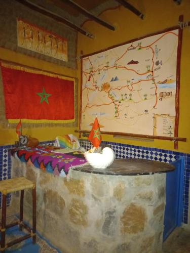 una habitación con un mapa en la pared y un cisne en una mesa en Riad gnaoua khamlia en Merzouga