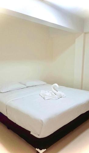 a bed with two white towels on top of it at บ้านพิชชา ที่พักใจกลางเมืองปราณบุรี in Ban Khao Noi