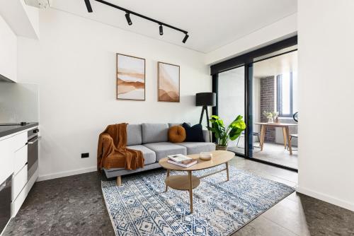 a living room with a couch and a table at Cinema Suites Apartments by Urban Rest in Sydney