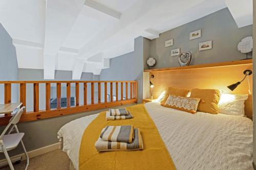 a bedroom with a large bed with a wooden headboard at Duplex 3 Bedroom Mezzanine Apartment - Heart of Edinburgh in Edinburgh