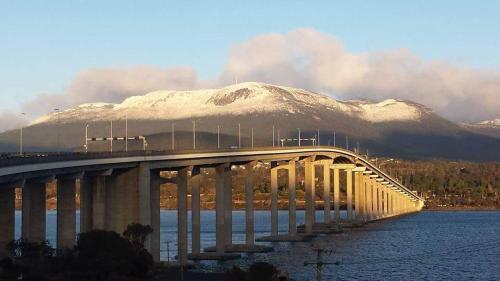 a bridge over a body of water with a mountain at 55 Davey Townhouse 2, Salamanca on your doorstep in Hobart