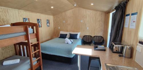 a small room with a bed and a desk at Queenstown Top 10 Holiday Park in Queenstown