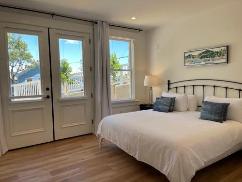 a bedroom with a bed and two windows at The Gables Inn Sausalito in Sausalito