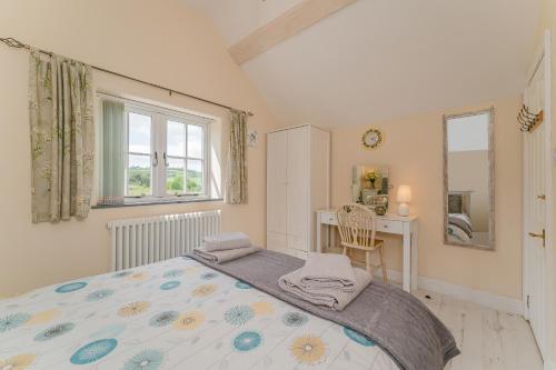 a bedroom with a bed and a desk and a window at Crown Cottage in Holywell