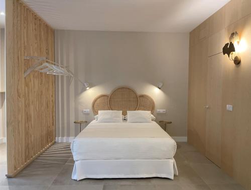 sypialnia z dużym łóżkiem z białą pościelą w obiekcie VIDAL APARTAMENTOS con parking privado. w mieście Carmona