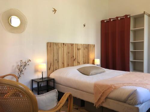 a bedroom with a bed with a wooden headboard at Studio paisible avec jardin - Tours centre in Tours