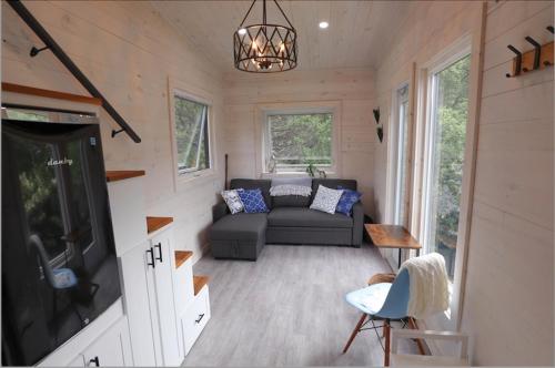 a living room in a tiny house with a couch at Blue Bayou Resort, Cape Breton in Dingwall