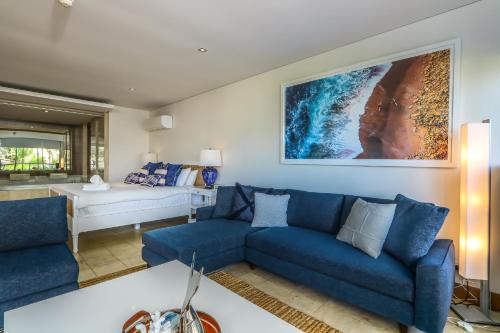 a living room with blue couches and a couch at Santai Sea-Duction in Casuarina