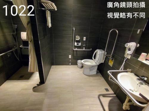 a bathroom with a toilet and a sink at Honest & Warm Hotel in Taoyuan