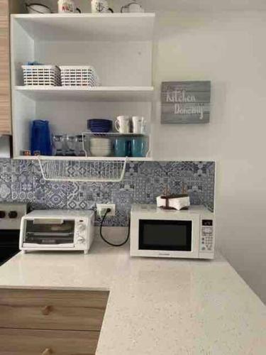 a kitchen counter with a microwave and a toaster oven at Wave nSea Monterrico in Monterrico