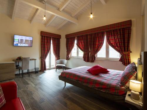a bedroom with a bed and a desk and two windows at Balneum Rooms & SPA in Mirabella Eclano