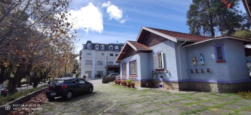 a car parked in front of a house at Pousada Vila Tio Lé in Campos do Jordão
