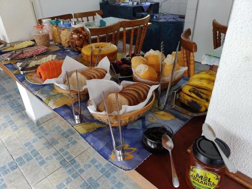 una tavola con diversi cesti di pane e altri alimenti di Pousada Vila Tio Lé a Campos do Jordão