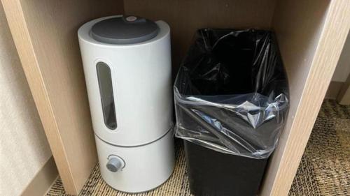 a white appliance sitting next to a trash can at Toyoko Inn Oita Ekimae in Oita