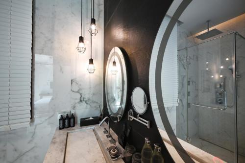 um banheiro com uma pia e um espelho em Glam Habitat - SHA Extra Plus em Kamala Beach